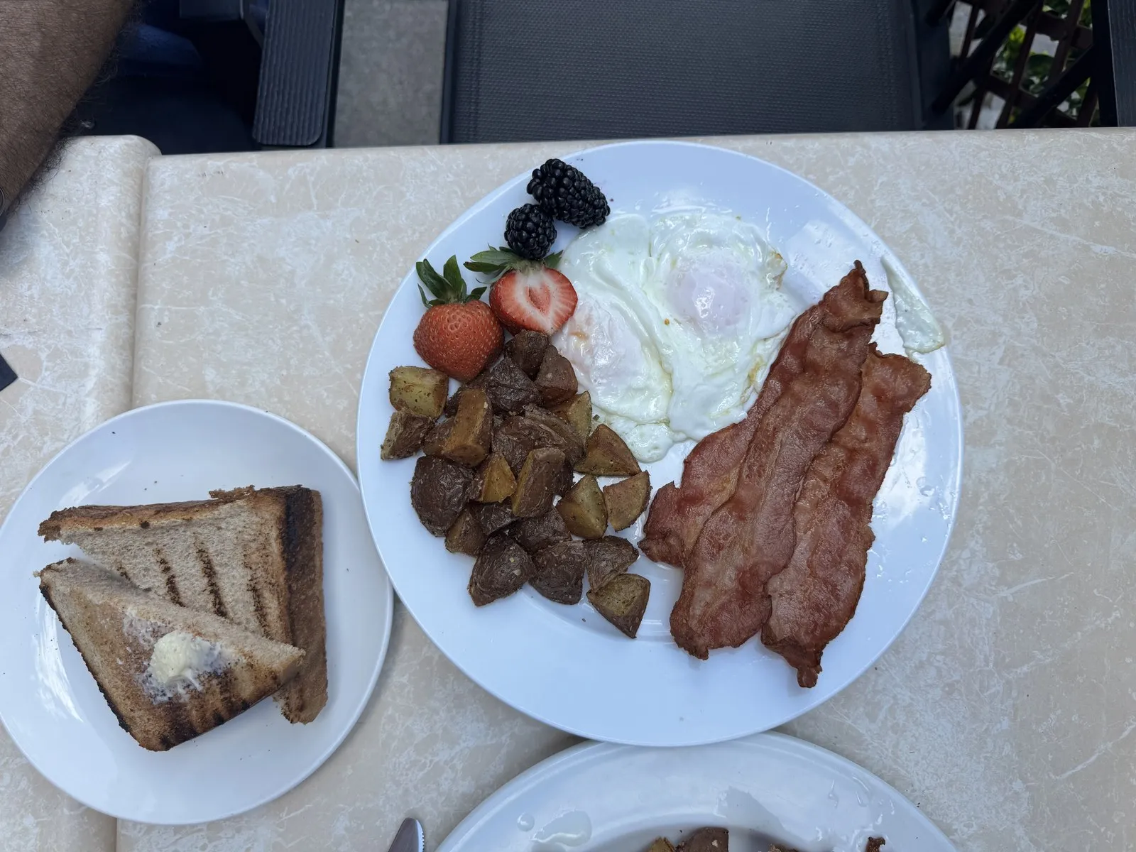 A classic Ace Restaurant breakfast plate: fried eggs, crispy bacon, roasted potatoes, grilled toast and fresh berries