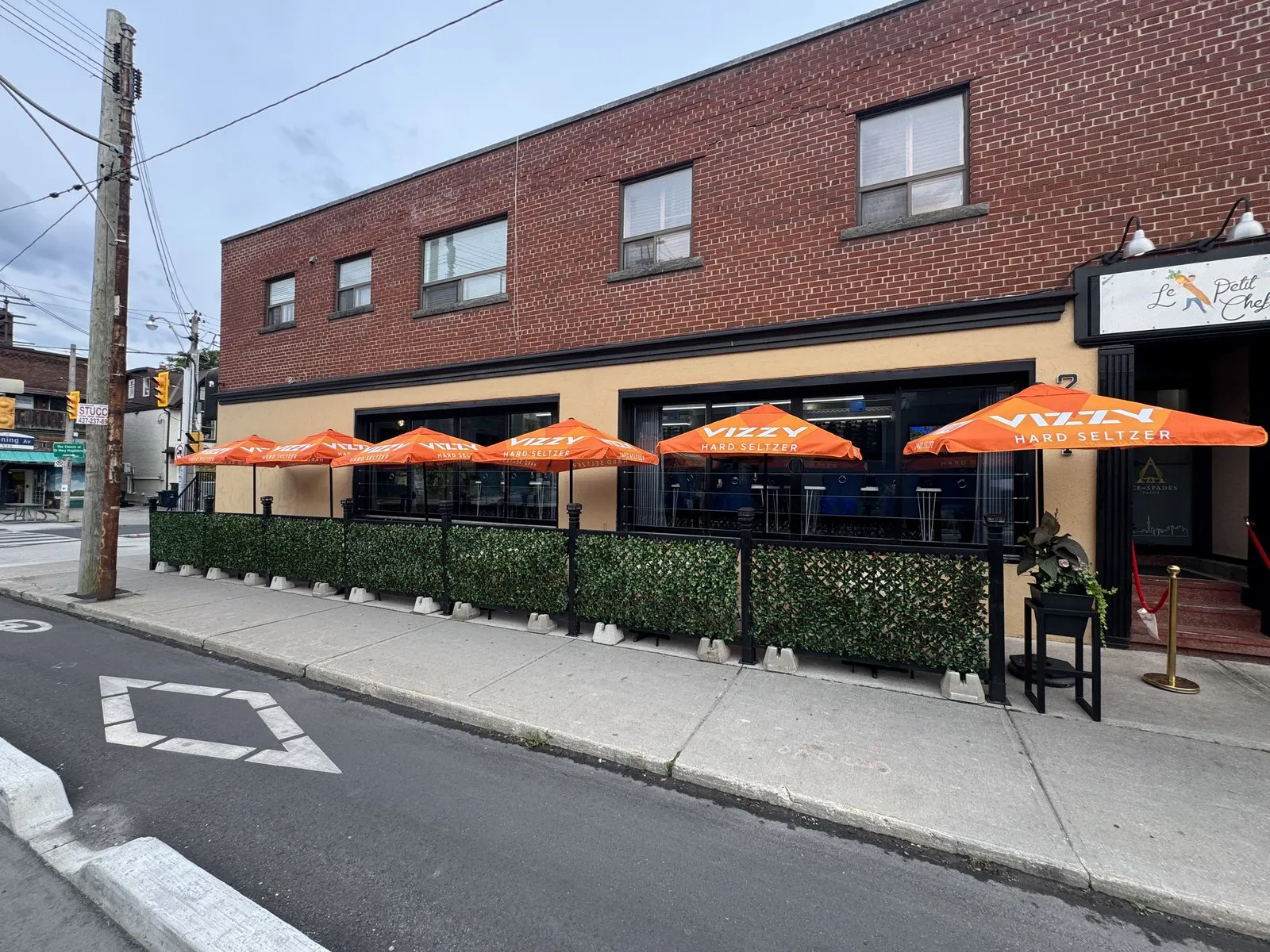 The full Ace Restaurant patio and storefront seen from across Harbord Street